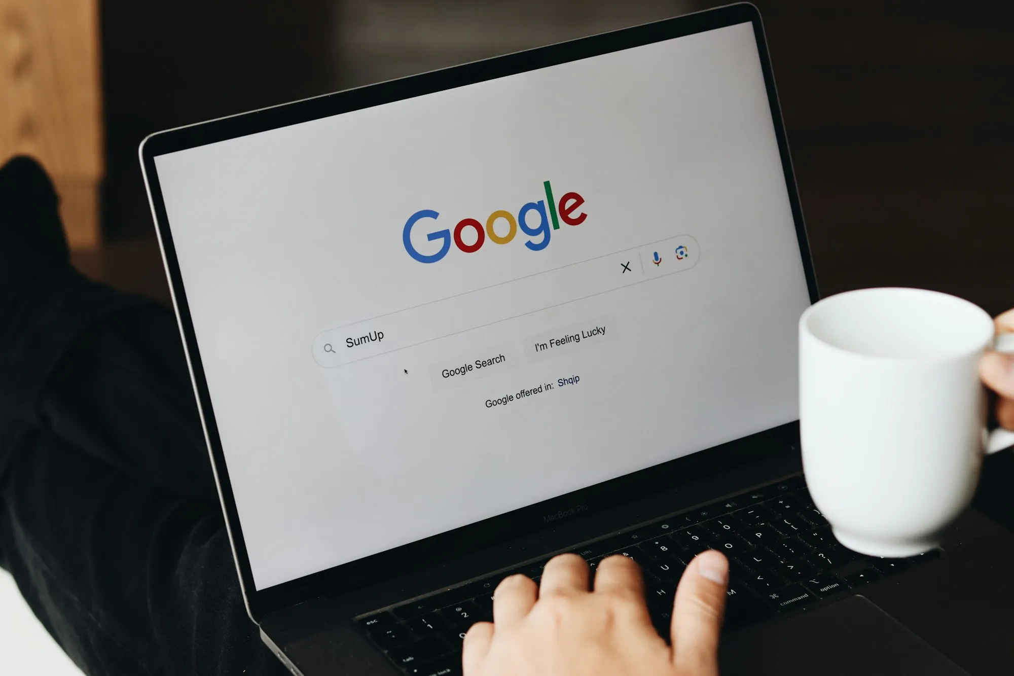 Someone running a Google search on a laptop