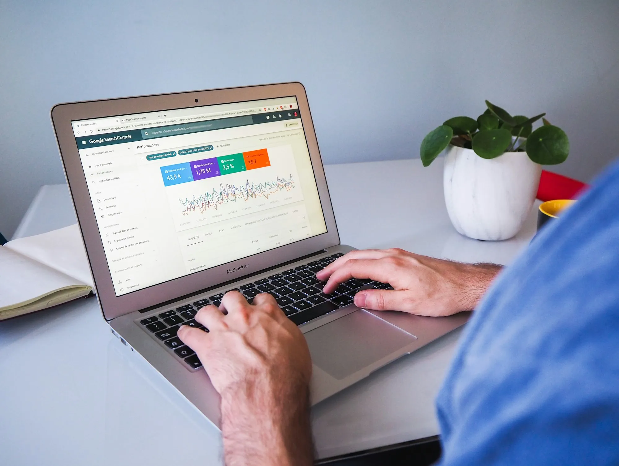 A laptop showing search performance data on a white desk